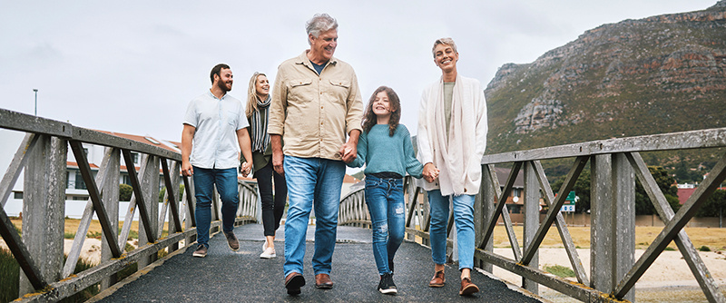 Young family with grandparents walking on bridge