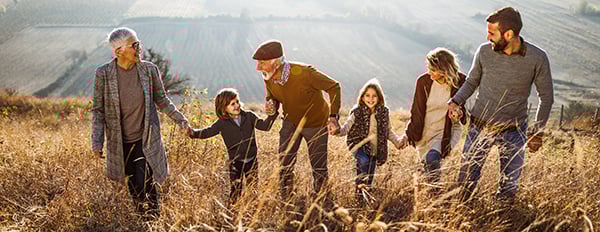 Multi-generation family walking up a hill on a fall day
