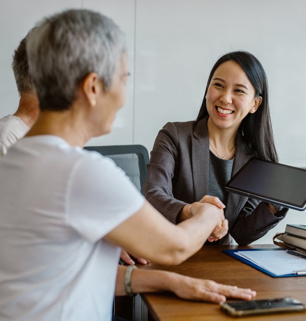 Mature woman shaking hand during client meeting