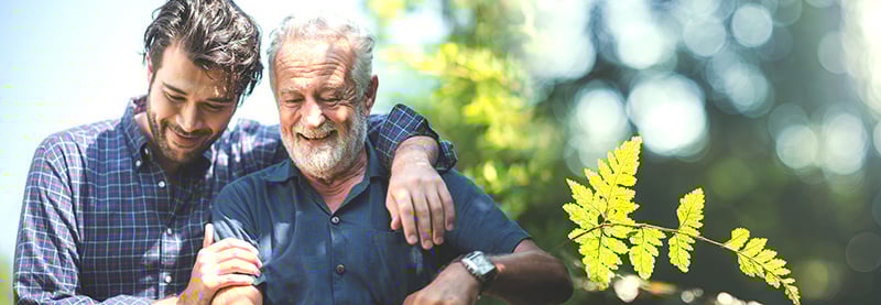 Adult son hugging old senior father
