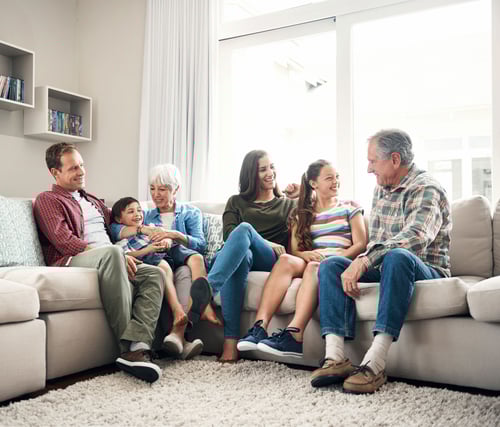 Three-generational family sitting together on a couch